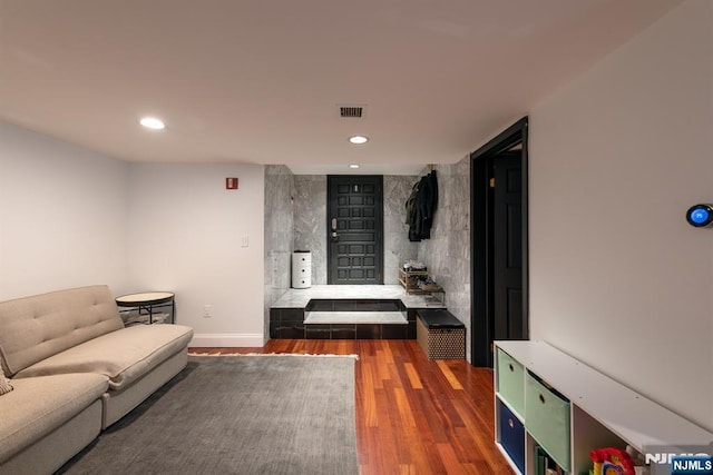 living area with baseboards, visible vents, wood finished floors, and recessed lighting