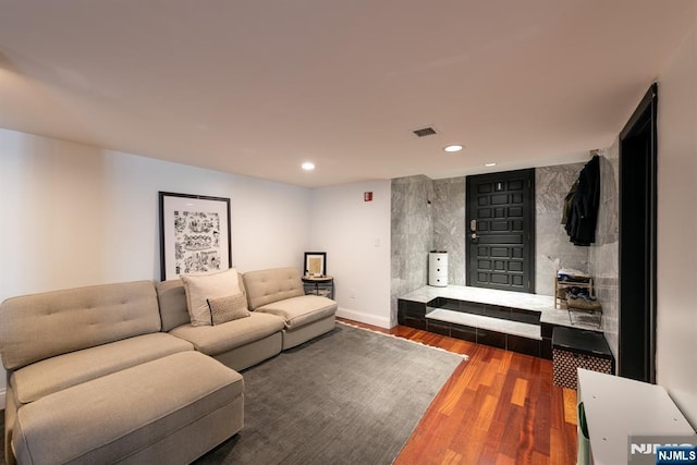 living room featuring baseboards, visible vents, wood finished floors, and recessed lighting