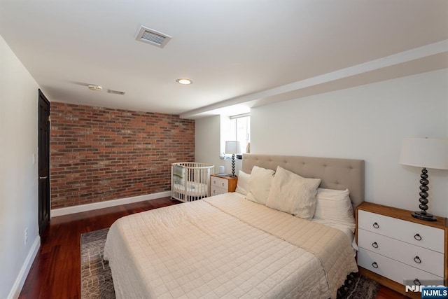 bedroom featuring baseboards, visible vents, brick wall, wood finished floors, and recessed lighting