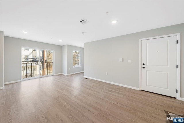 unfurnished living room featuring light wood-type flooring, visible vents, baseboards, and recessed lighting