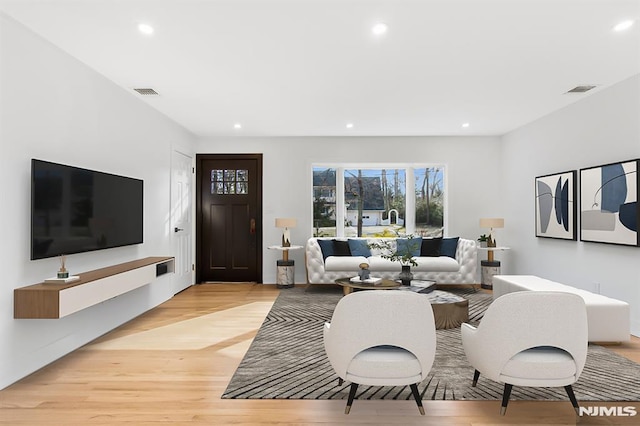 living area featuring light wood finished floors, visible vents, and recessed lighting