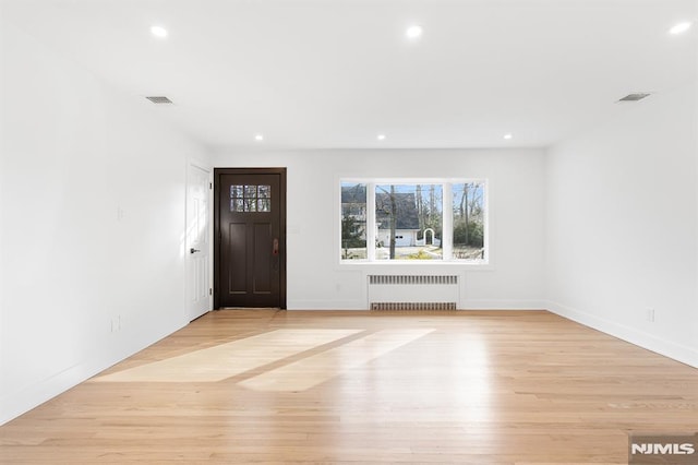 entryway with radiator, light wood-style flooring, visible vents, and recessed lighting