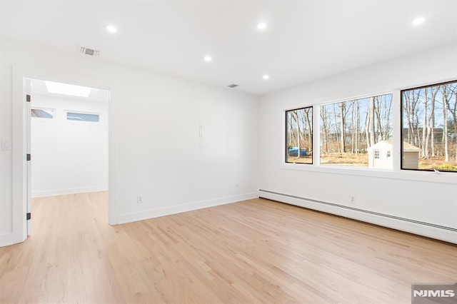 unfurnished room featuring visible vents, baseboards, a baseboard radiator, light wood-style flooring, and recessed lighting