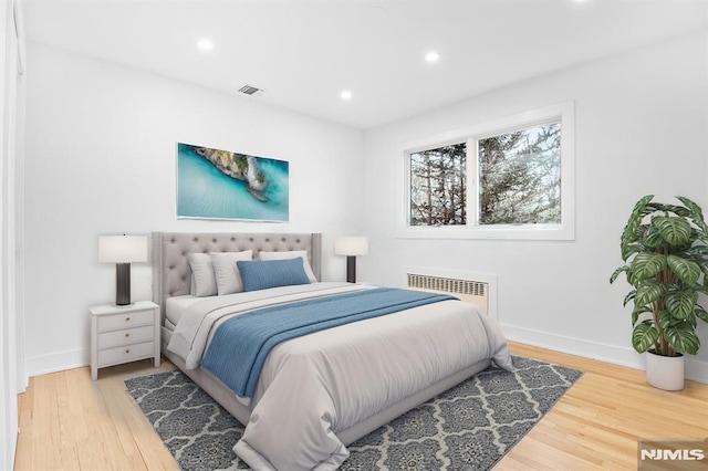 bedroom with baseboards, visible vents, wood finished floors, and recessed lighting