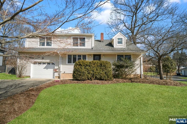 view of front facade featuring an attached garage, driveway, a chimney, and a front yard