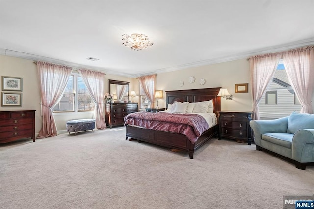 carpeted bedroom featuring ornamental molding and visible vents