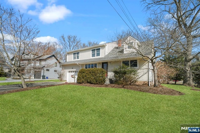 view of front of home featuring aphalt driveway, a front yard, and an attached garage