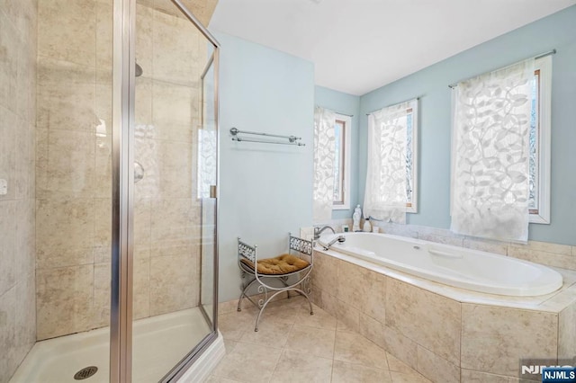 bathroom featuring tile patterned floors, a shower stall, and a bath