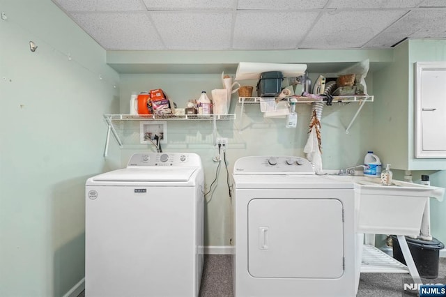 clothes washing area featuring laundry area, baseboards, and washing machine and clothes dryer