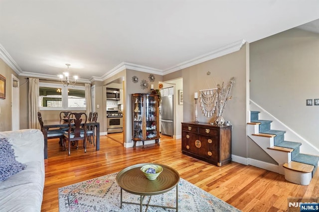 living room with ornamental molding, stairway, and wood finished floors