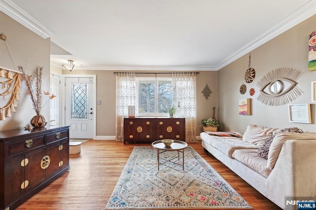 living room featuring crown molding, baseboards, and wood finished floors