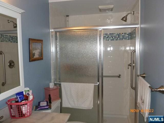 bathroom featuring a stall shower, vanity, and toilet