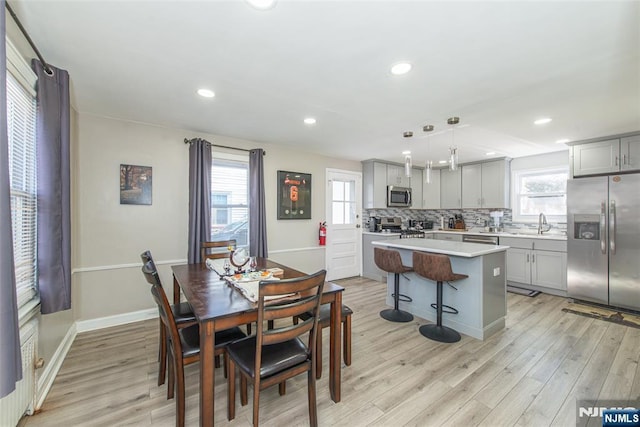 dining space featuring recessed lighting, light wood-style flooring, and baseboards