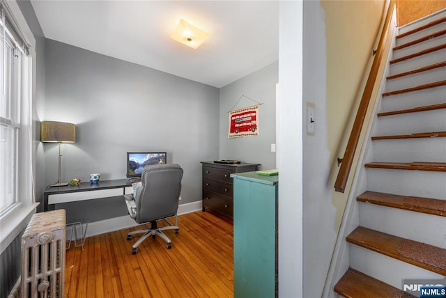 office area with baseboards, radiator, and hardwood / wood-style floors