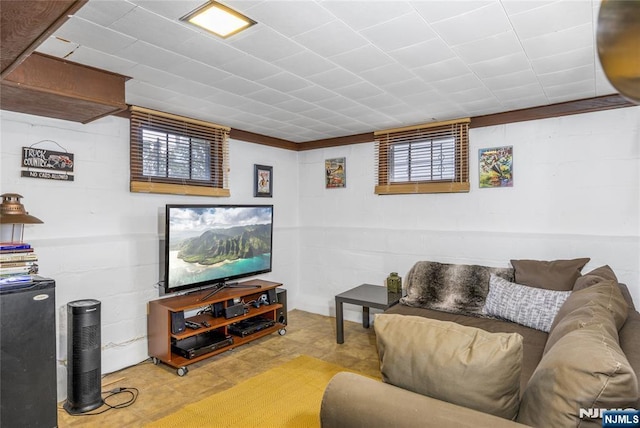 living area with concrete block wall