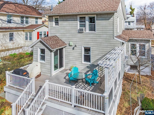 rear view of property with cooling unit and a shingled roof