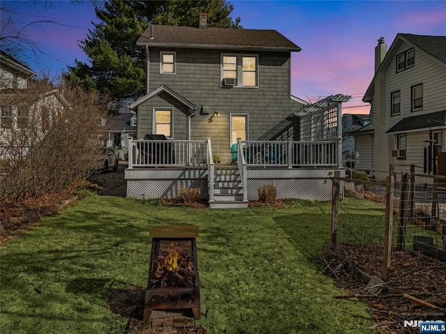 back of property featuring fence, roof with shingles, a yard, a chimney, and a deck