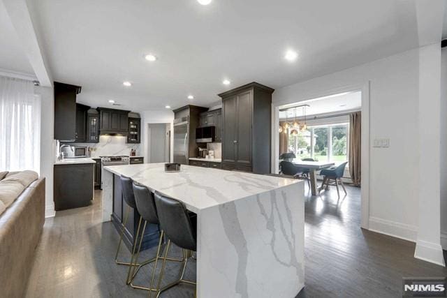 kitchen with dark wood-type flooring, recessed lighting, stainless steel appliances, and a center island