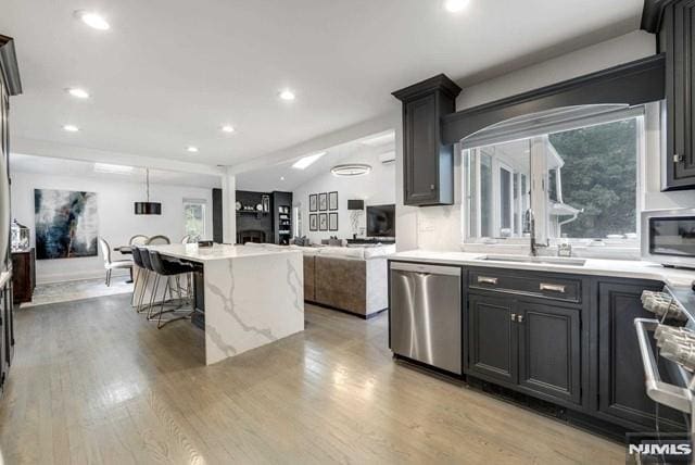 kitchen with a sink, plenty of natural light, light wood-style floors, and appliances with stainless steel finishes