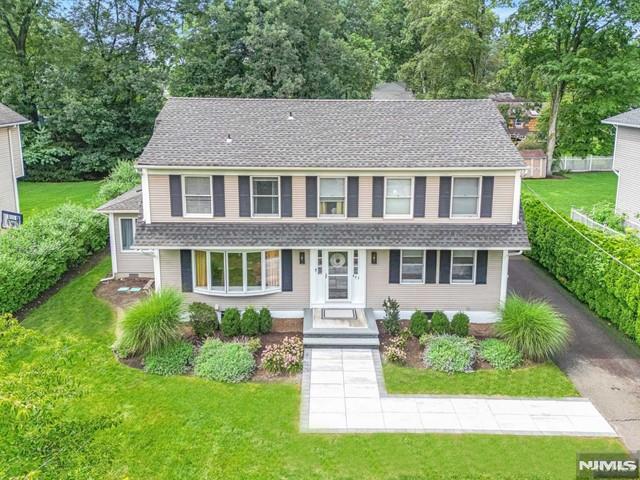 view of front of home with a shingled roof and a front yard