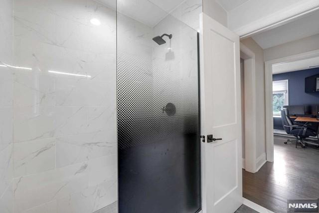 full bathroom featuring wood finished floors and a walk in shower