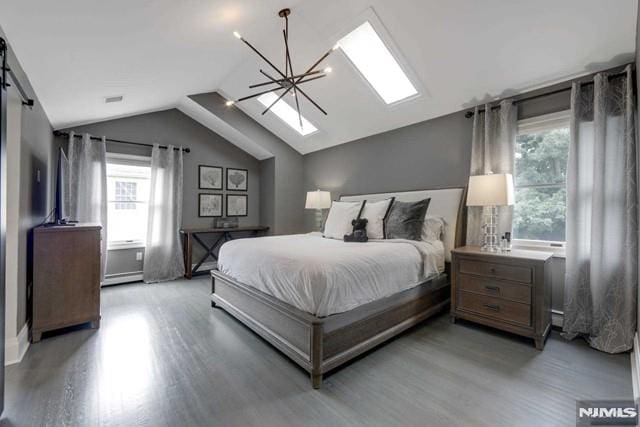 bedroom with a barn door, light wood-style flooring, an inviting chandelier, and vaulted ceiling