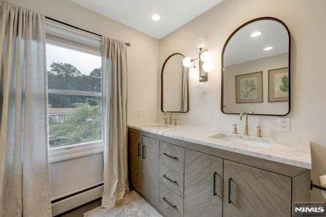 bathroom featuring a baseboard heating unit, double vanity, recessed lighting, and a sink