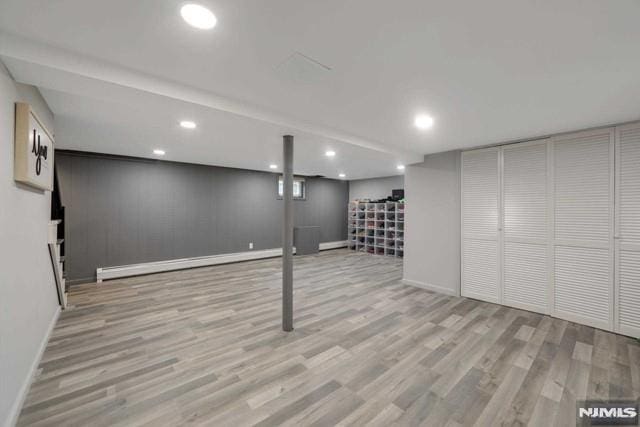 finished basement featuring recessed lighting, wood finished floors, and baseboard heating