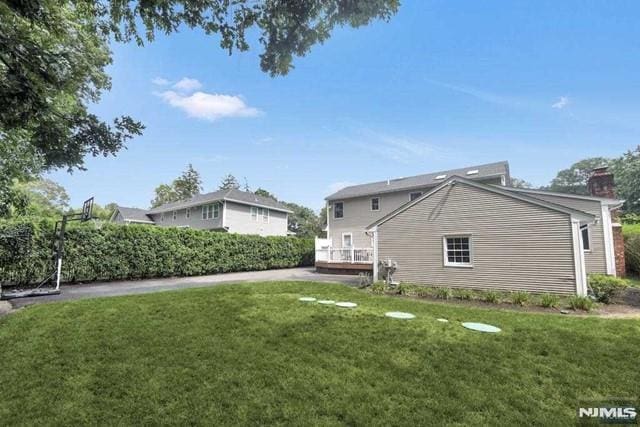 back of property featuring a lawn and a chimney