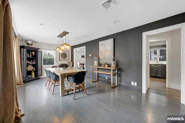 dining room with visible vents, baseboards, a notable chandelier, and wood finished floors