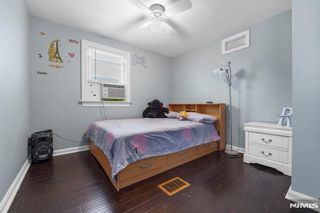 bedroom featuring cooling unit, visible vents, baseboards, and wood finished floors