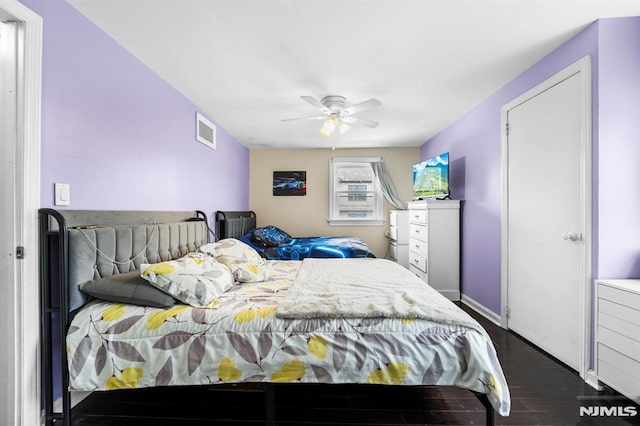 bedroom with visible vents, ceiling fan, baseboards, and wood finished floors