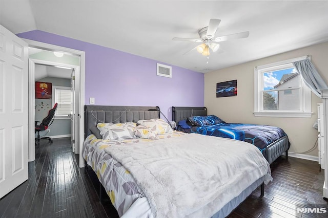 bedroom featuring lofted ceiling, dark wood-style flooring, visible vents, and baseboards