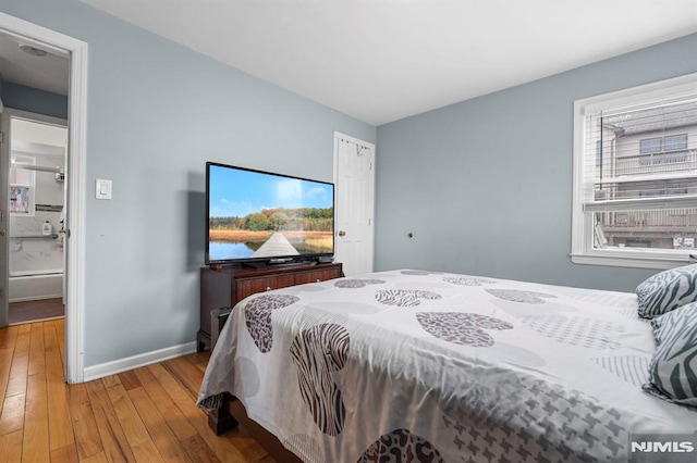 bedroom featuring light wood finished floors and baseboards