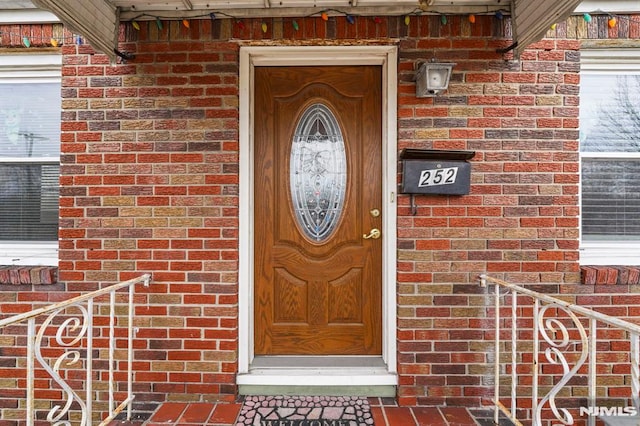 property entrance featuring brick siding