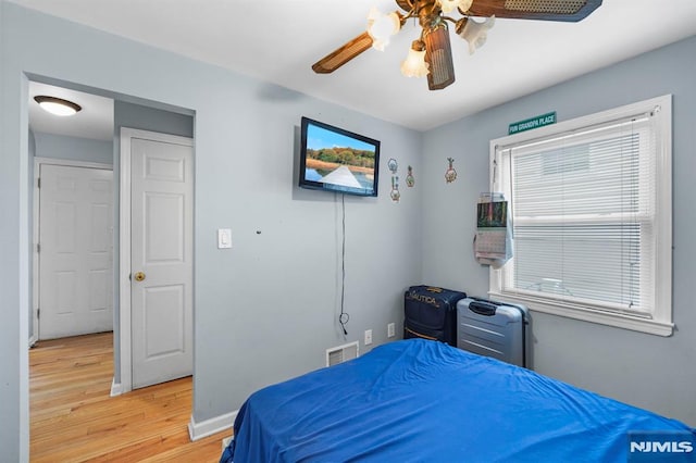 bedroom featuring visible vents, ceiling fan, light wood-style flooring, and baseboards