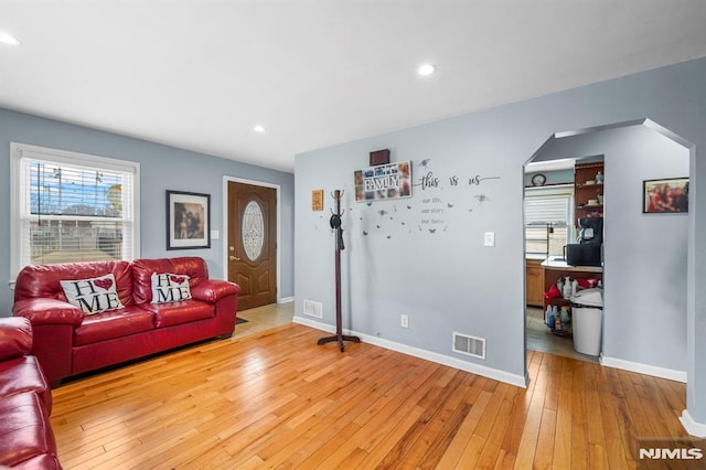 living area with light wood finished floors, recessed lighting, visible vents, and baseboards