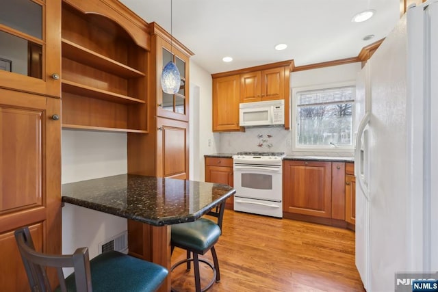 kitchen featuring white appliances, brown cabinets, visible vents, and light wood finished floors