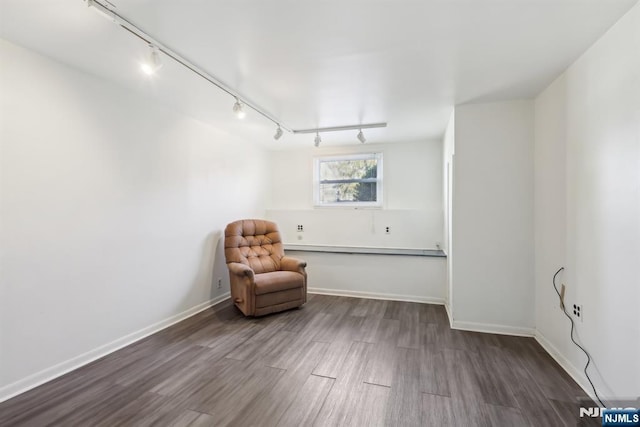 sitting room with track lighting, baseboards, and wood finished floors