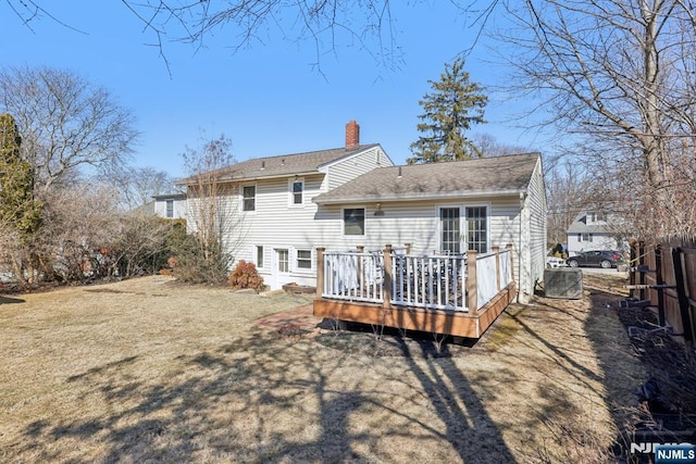 back of property featuring central AC unit, a lawn, a chimney, fence, and a wooden deck