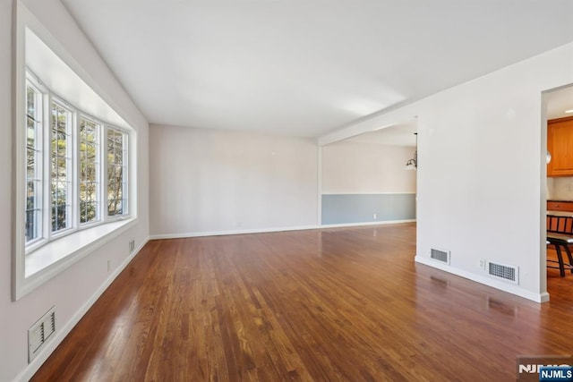 spare room with wood finished floors and visible vents