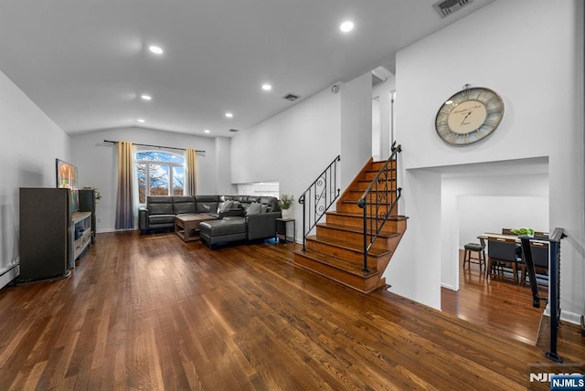 living area featuring lofted ceiling, hardwood / wood-style flooring, visible vents, and stairs