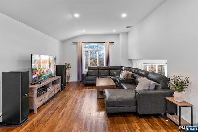 living room with lofted ceiling, visible vents, wood finished floors, and recessed lighting