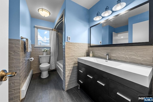 full bath with tile walls, toilet, a baseboard heating unit, wood tiled floor, and wainscoting