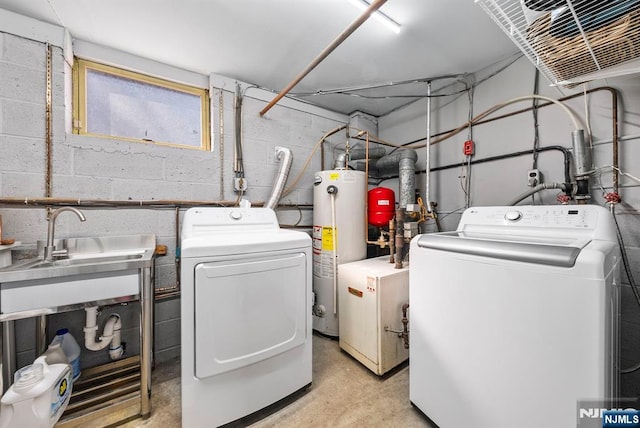 laundry room with laundry area, water heater, washer and clothes dryer, and a sink