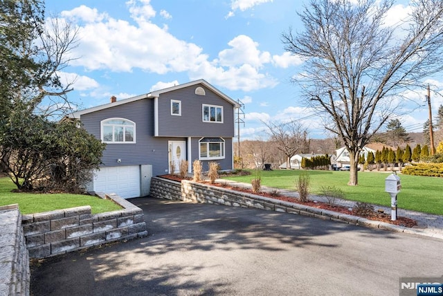 view of front of home with a garage, aphalt driveway, and a front yard