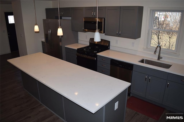 kitchen featuring black appliances, light countertops, dark wood-type flooring, and a sink