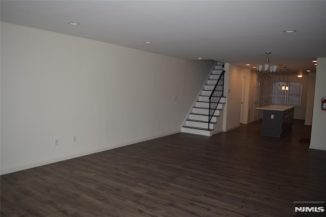 198 Wallace St, Orange, NJ 07050 - unfurnished living room with baseboards, an inviting chandelier, recessed lighting, dark wood-style flooring, and stairs