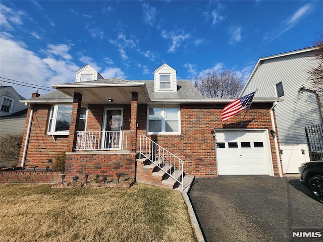 view of front of property featuring a garage, covered porch, brick siding, and aphalt driveway