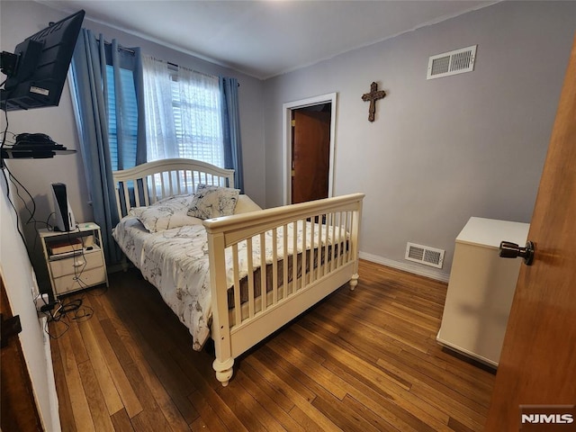 bedroom featuring baseboards, visible vents, and hardwood / wood-style floors